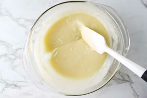 Glass bowl melted white chocolate.