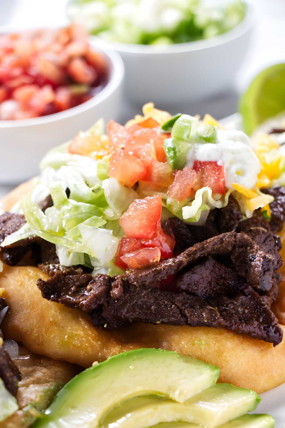 Fry bread topped with steak and taco toppings.