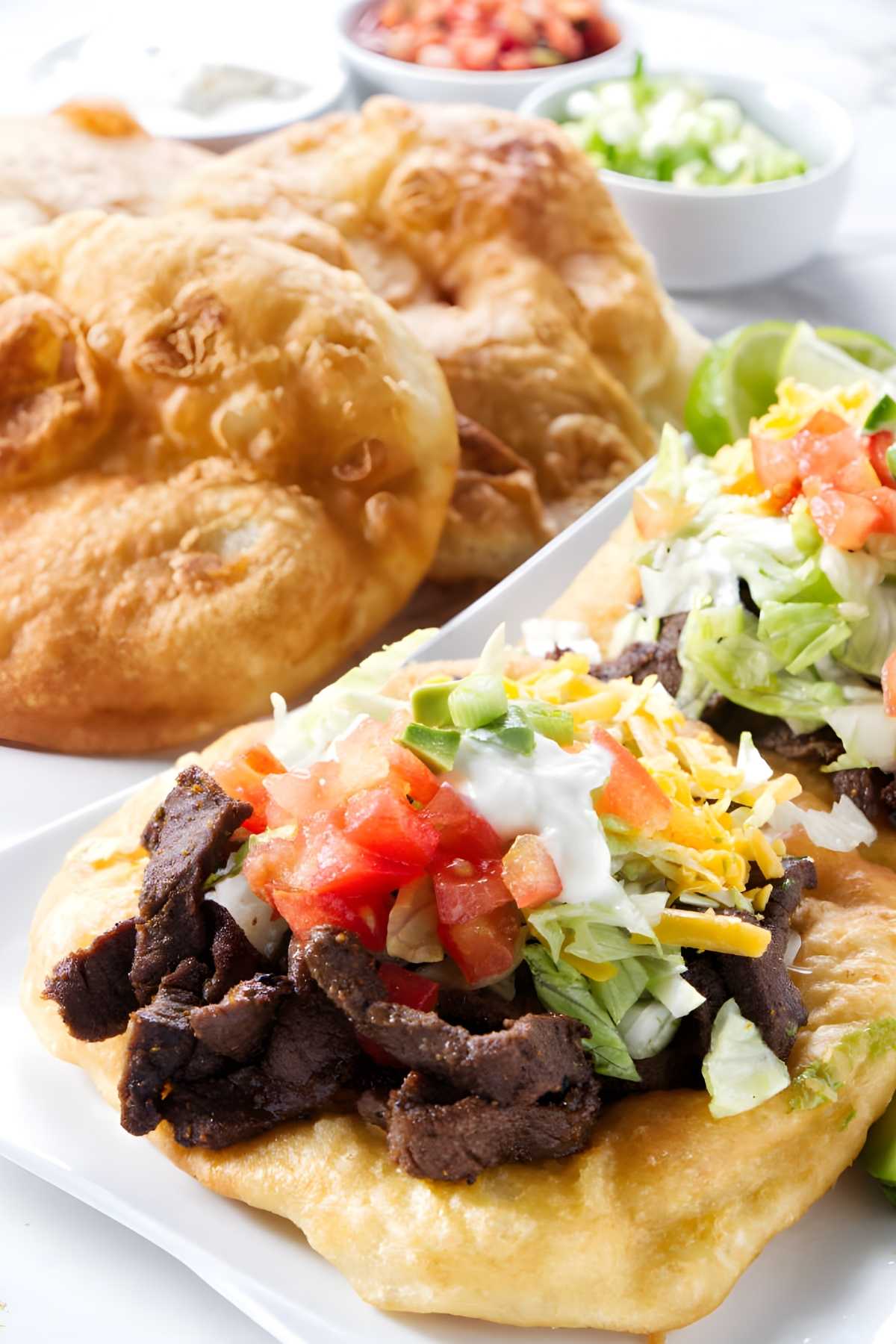 Navajo taco with beef, lettuce, cheese, tomatoes, and sour cream on fry bread.