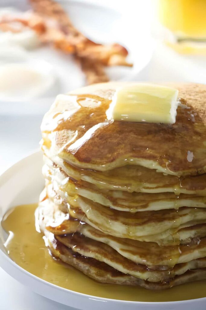 Stack of pancakes made with a sourdough starter next to orange juice. 