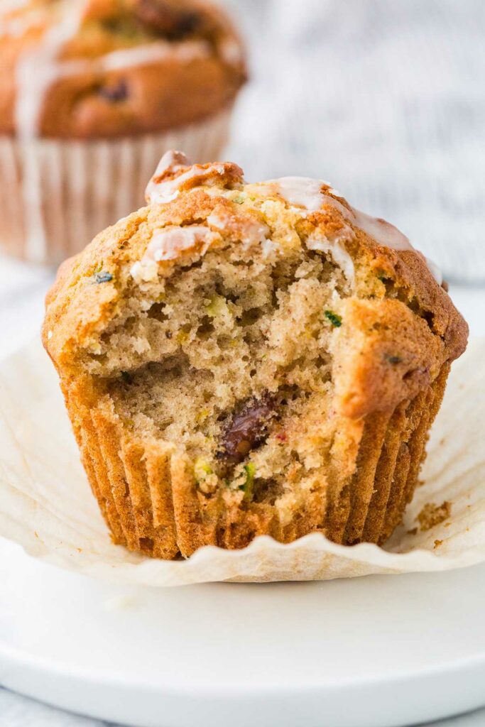 A bite taken out of a zucchini breakfast muffin with chopped dates.