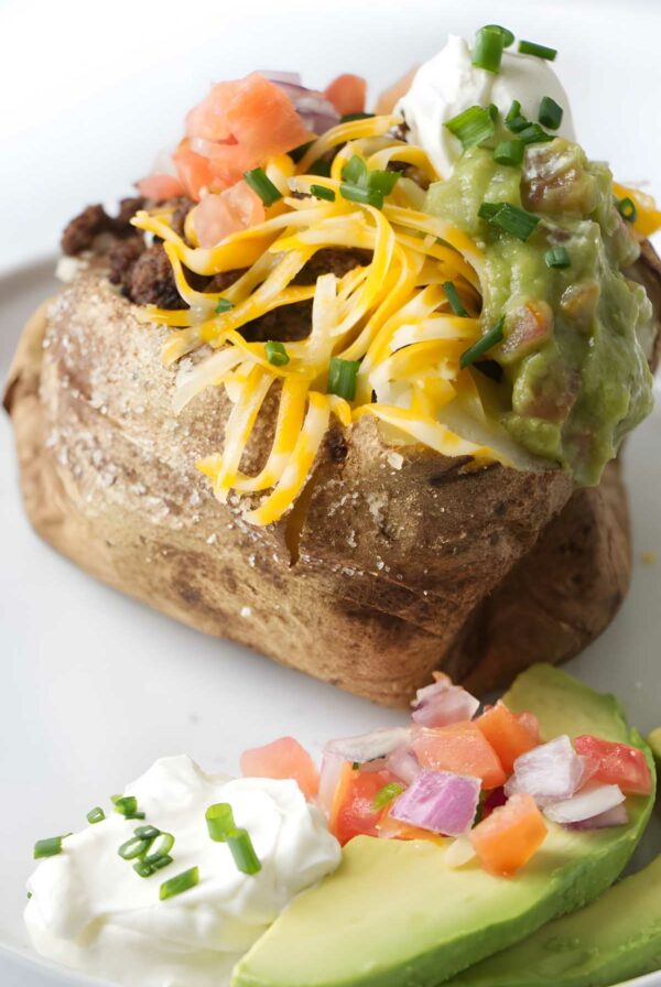 A taco stuffed baked potato on a plate.