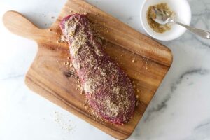 Adding seasoning to a steak.