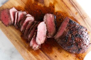 Slicing a steak on a cutting board.
