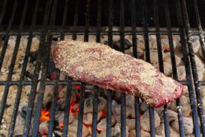 Grilling a steak over hot coals.