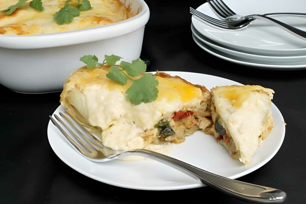 Slice of creamy enchilada casserole on plate, garnished with cilantro.