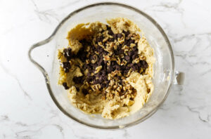 Adding nuts and chocolate chips to cookie dough.