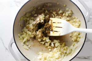 Sautéing onions and spices in a skillet.