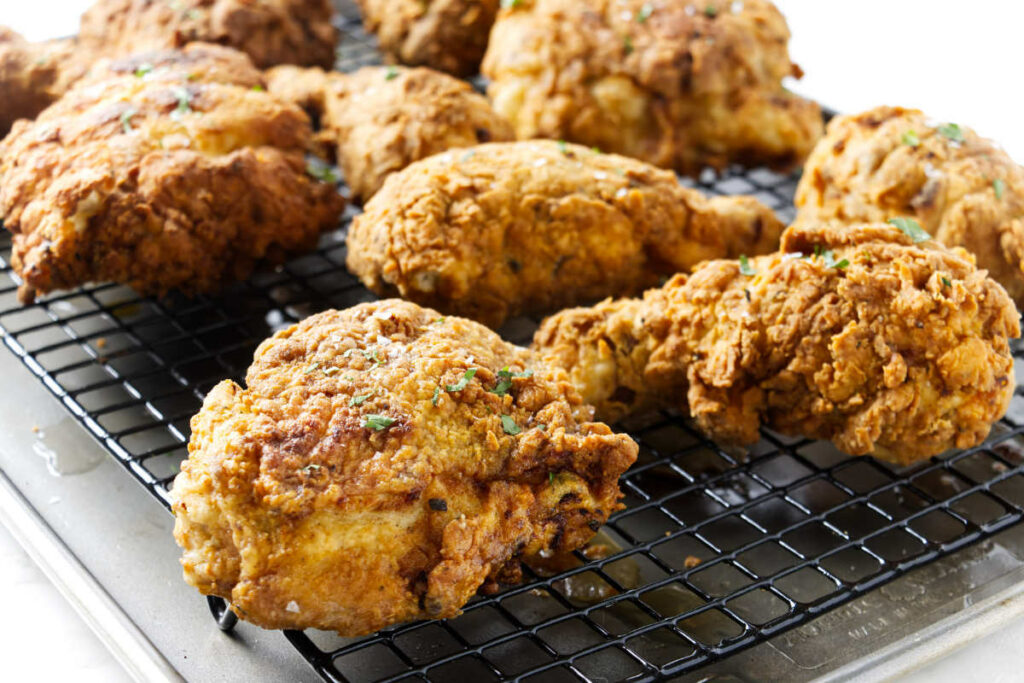 Several pieces of southern fried chicken on a rack.