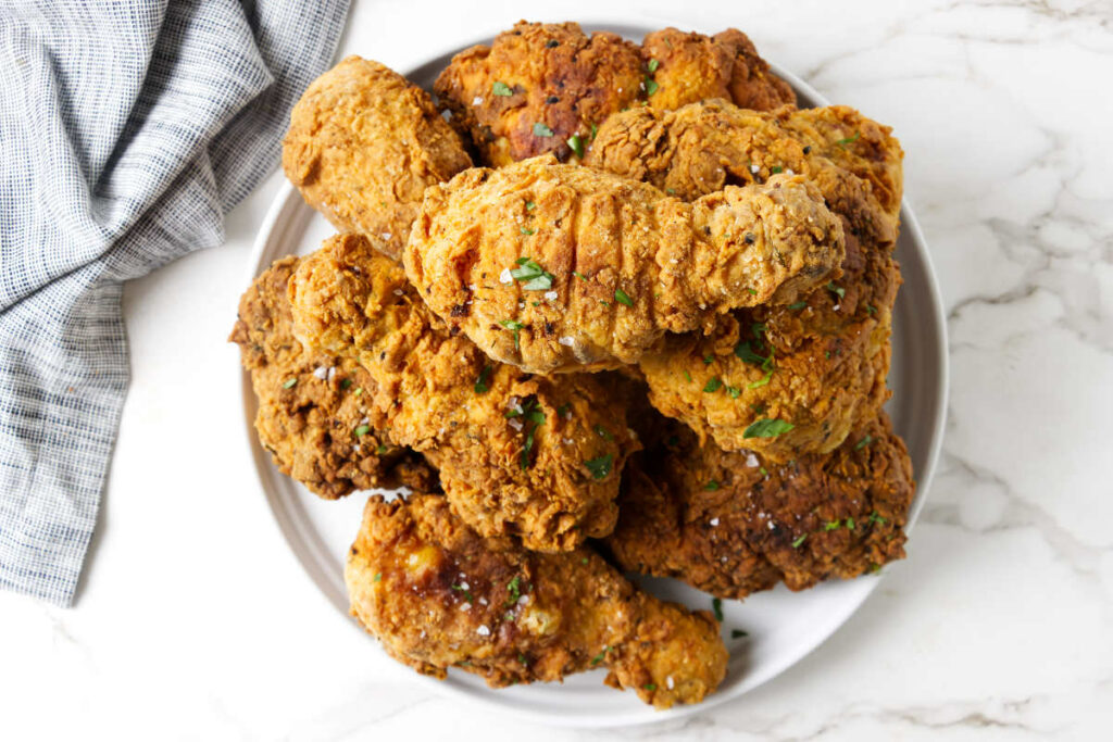 A plate filled with a stack of buttermilk brined fried chicken.