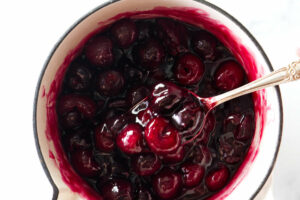 Stirring cherry compote in a sauce pan.