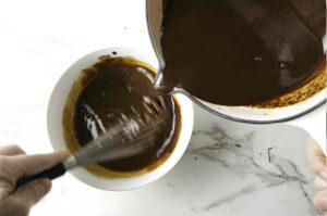 Tempering egg yolks with hot cocoa.