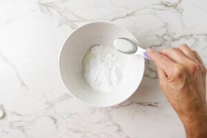 Making a sugar glaze for the tops of homemade muffins.