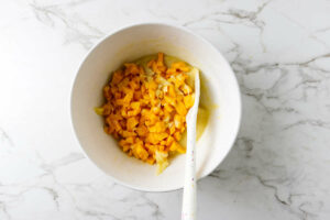 Adding diced mango to the muffin batter.