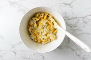 Stirring mangoes into muffin batter.
