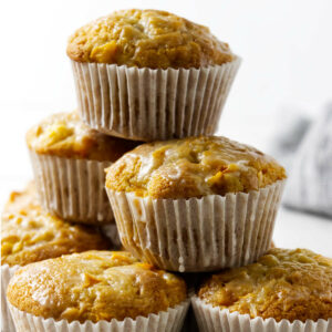 A stack of six coconut mango muffins wrapped in paper.