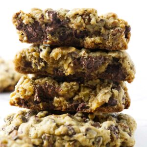 A stack of chocolate chip walnut cookies on a white counter.