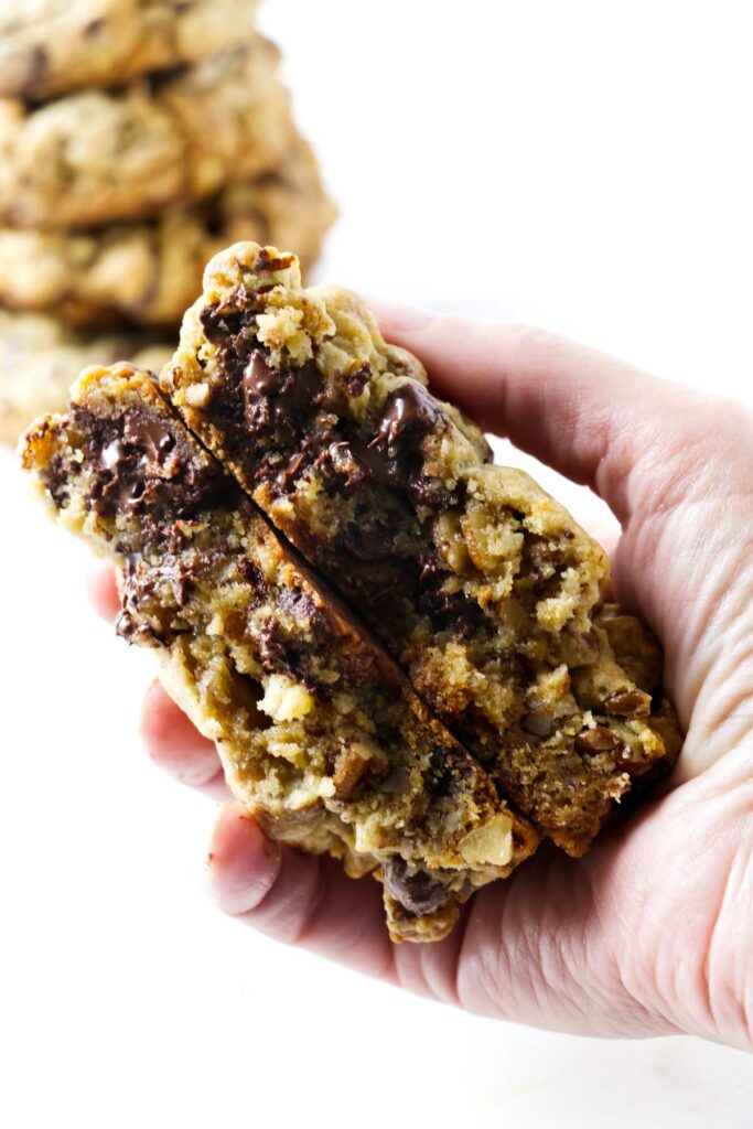 A hand holding levain bakery cookies.