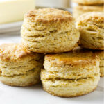 A stack of four biscuits showing flaky layers and golden brown tops.