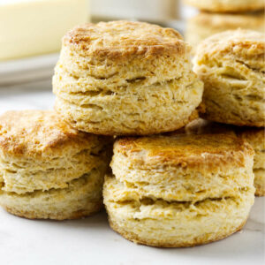 A stack of four biscuits showing flaky layers and golden brown tops.