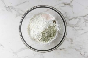 Mixing flour with spices and seasonings.