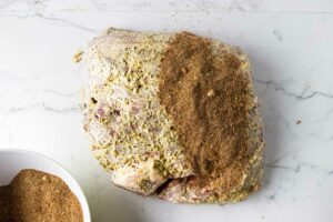 Adding a dry bbq rub over a slab of Boston butt.