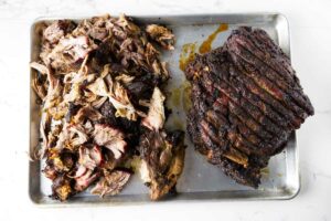 Shredding a boston pork butt on a sheet pan.