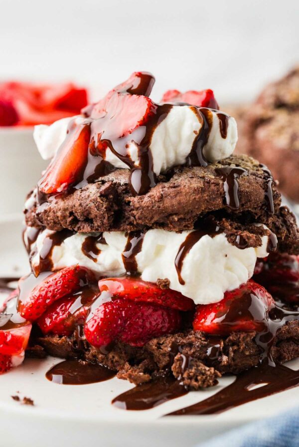 A chocolate sourdough strawberry shortcake topped with chocolate sauce.