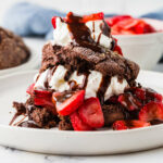 A chocolate sourdough strawberry shortcake and a bowl of strawberries.
