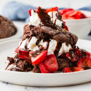 A chocolate sourdough strawberry shortcake and a bowl of strawberries.