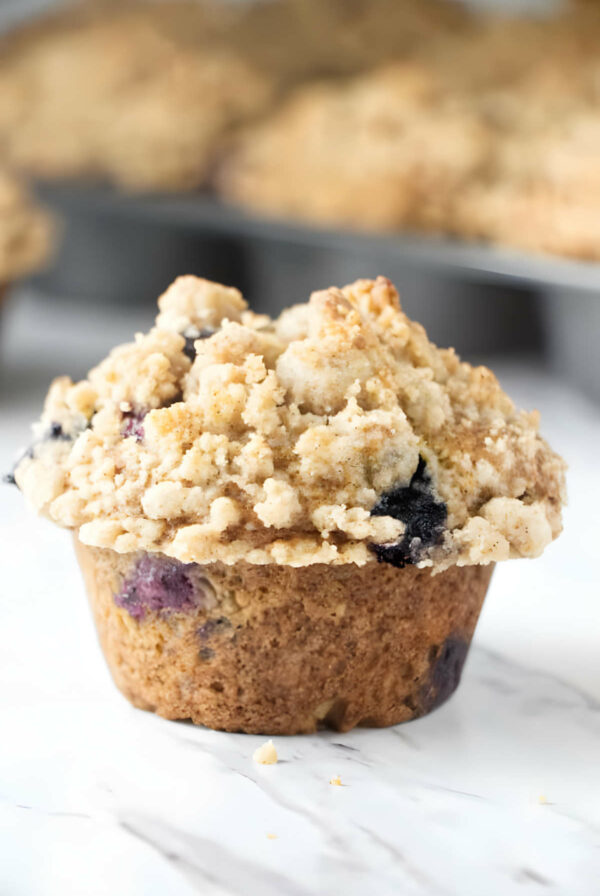 A freshly baked muffin with a streusel topping and blueberries.