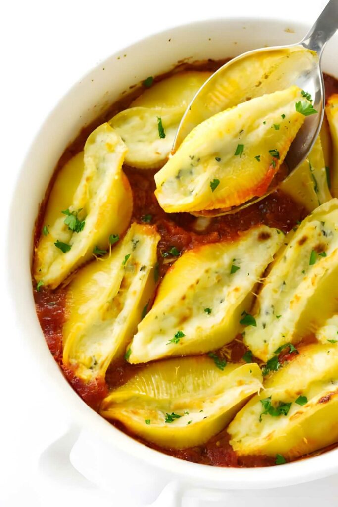 Stuffed pasta shells in tomato sauce with parsley.