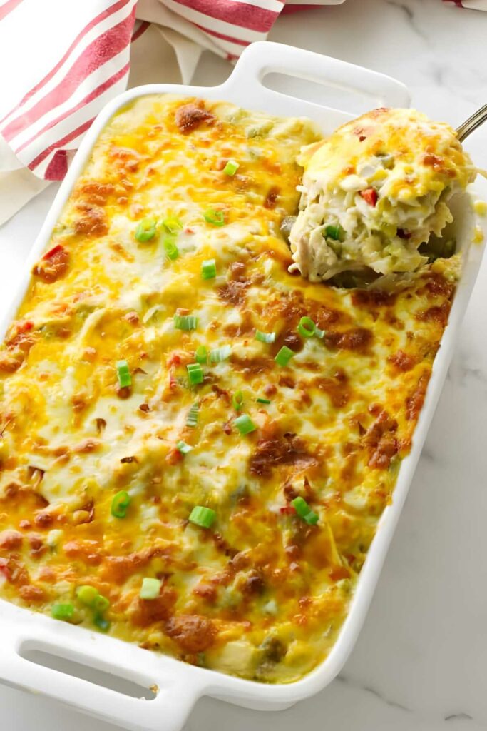 Baked chicken casserole with green onions in white dish.
