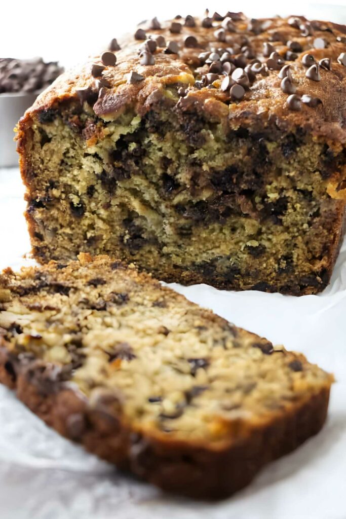 Sliced chocolate chip banana bread with moist interior and chocolate chips on top.