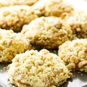 Close-up of cranberry muffins with streusel topping on a baking tray.