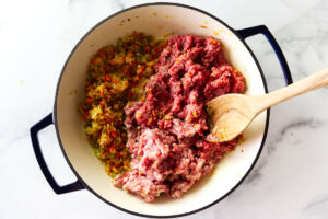 Cooking ground beef and ground pork in a skillet with the veggies.