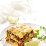 Slice of breakfast casserole, garnished with cilantro and lime.