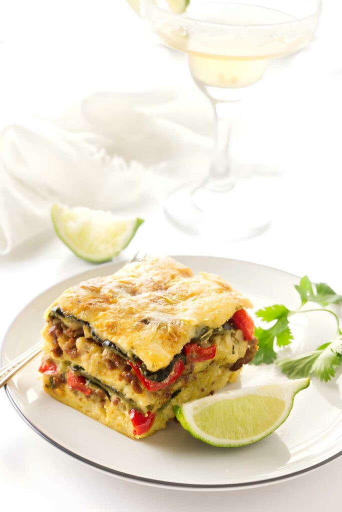 Slice of breakfast casserole, garnished with cilantro and lime.
