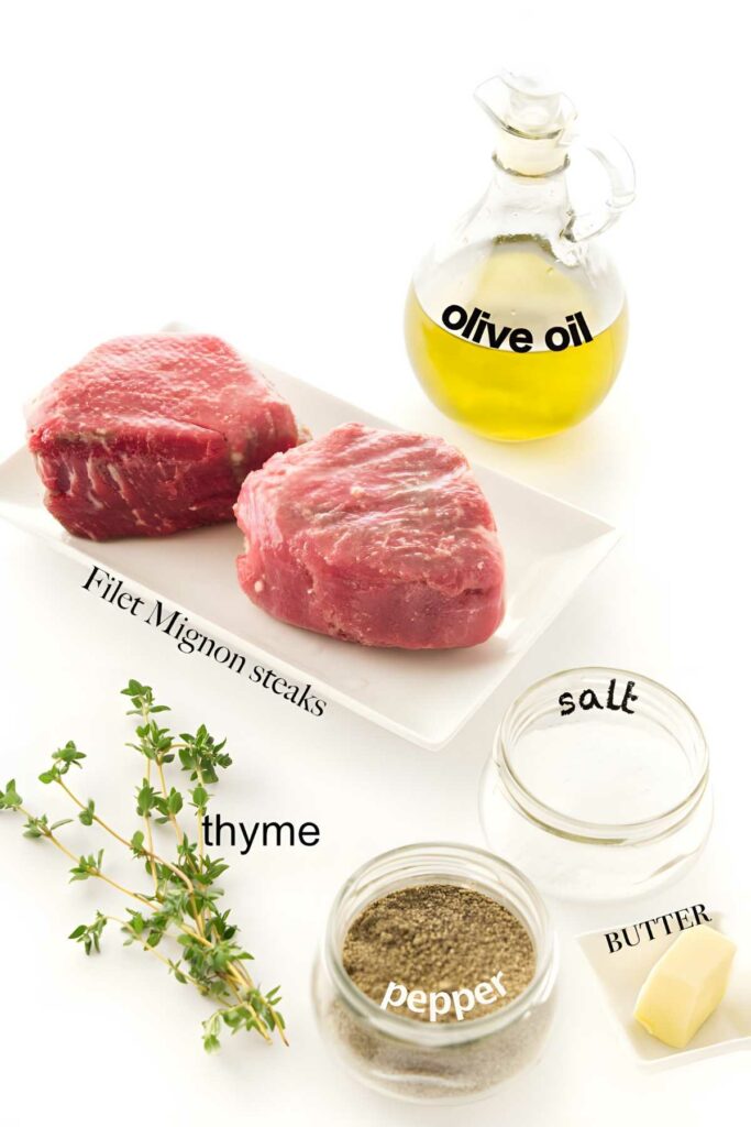 Two raw filet mignons with labeled seasoning ingredients on a white background.