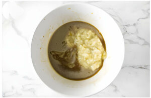 Stirring mashed banana into muffin batter.