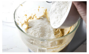 Adding flour to cookie dough.