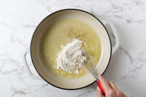 Whisking flour into the melted butter.