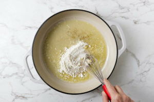 Stirring flour into the hot butter in a skillet.
