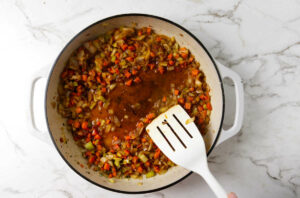 Adding wine or broth to the pan to deglaze the pan.