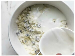 Adding buttermilk to scone dough.