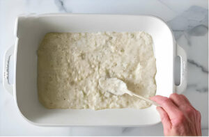 A creamy white sauce in a lasagna dish.