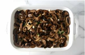 Adding a layer of roasted mushrooms to a lasagna dish.