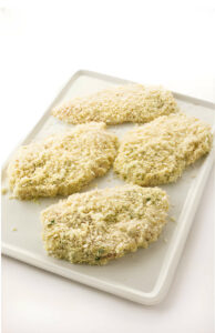 Chicken cutlets coated in panko and sitting on a plate.