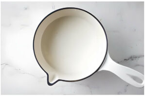 Bringing milk to a simmer in a pot.