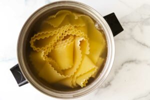 Lasagna noodles in a pot of hot water.